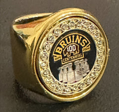 The deCAPitator BRUINS CENTENNIAL 1924 to 2024 ring bottle cap and can tab opener. Sizes 6 to 15 with ring sizer. Made of stainless steel.