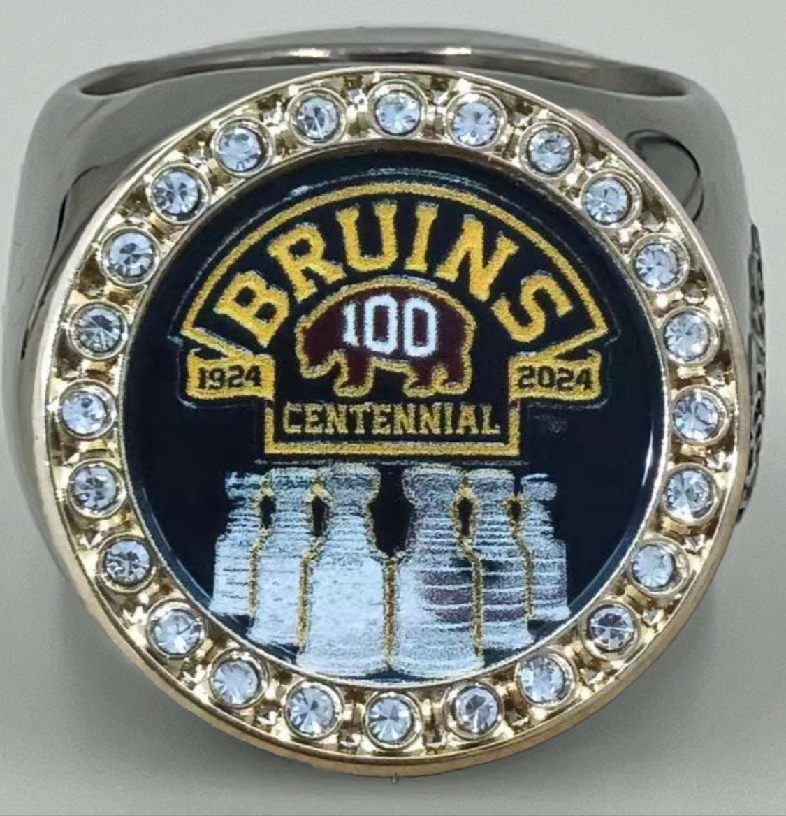 The deCAPitator BRUINS CENTENNIAL 1924 to 2024 ring bottle cap and can tab opener. Sizes 6 to 15 with ring sizer. Made of stainless steel.